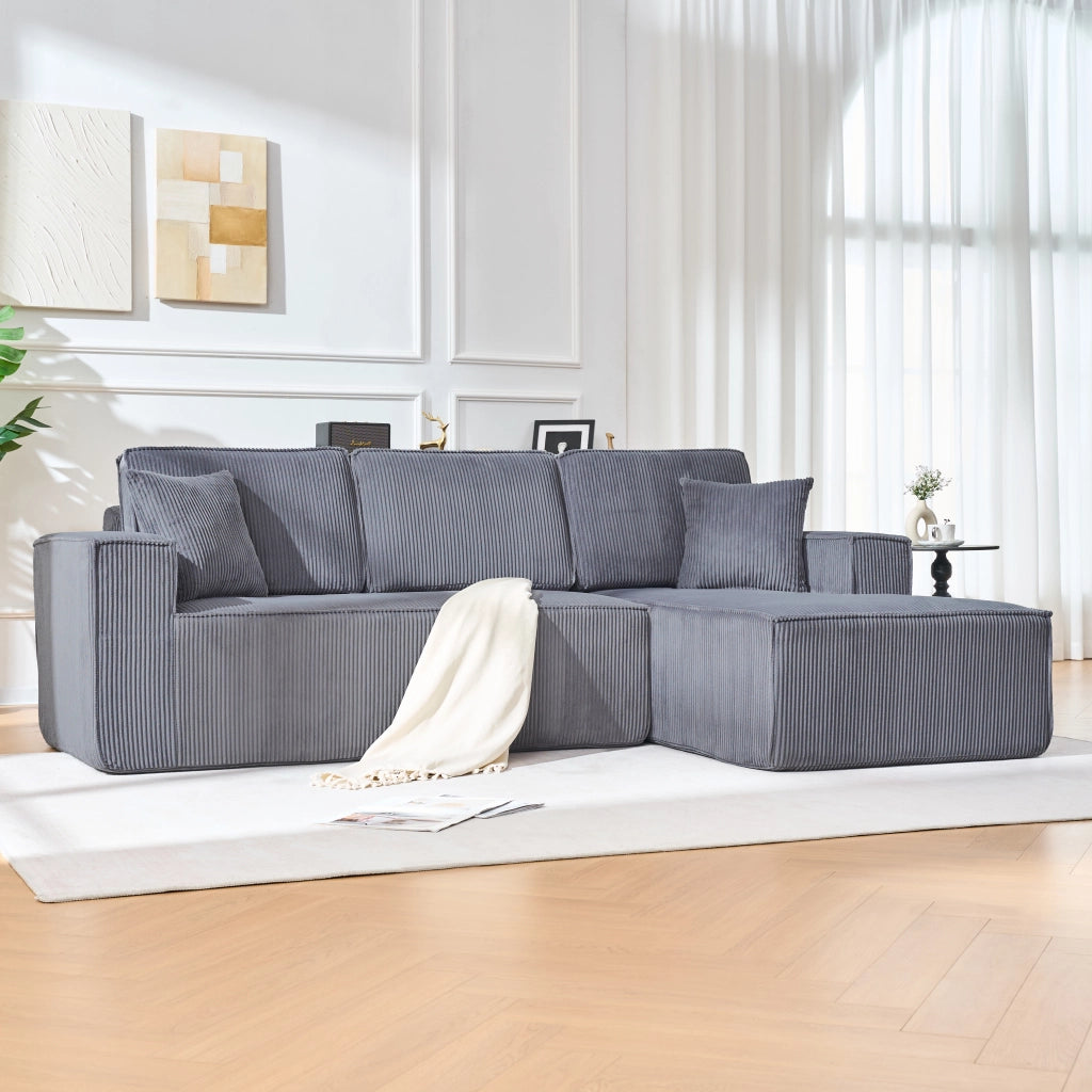 Divano angolare modulare 2 posti con chaise longue, due cuscini e braccioli larghi in velluto a coste grigio