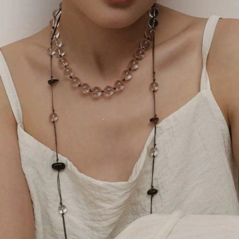 Collana con nappa in corda intrecciata e perline trasparenti a blocchi di colore