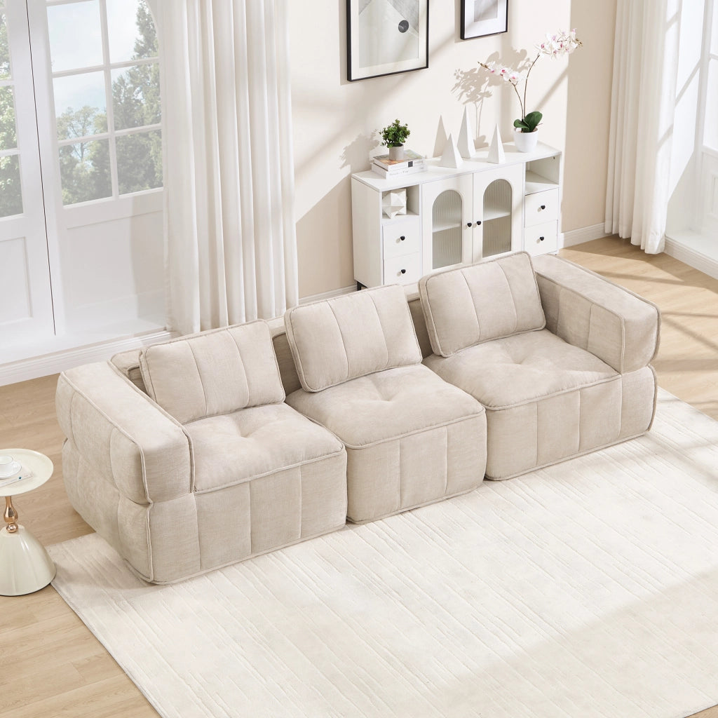 Divano modulare a 3 posti in poliestere beige con seduta profonda, braccioli larghi e base antiscivolo 67 × 271 × 93 cm