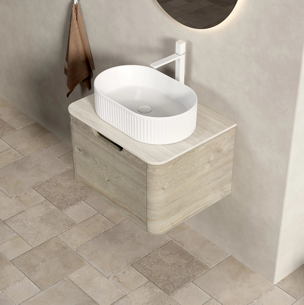 Mobile bagno sospeso 60 cm con lavabo ovale bianco in ceramica, piano in travertino sinterizzato e armadietto in compensato con cassetto, finitura rovere crema, preassemblato