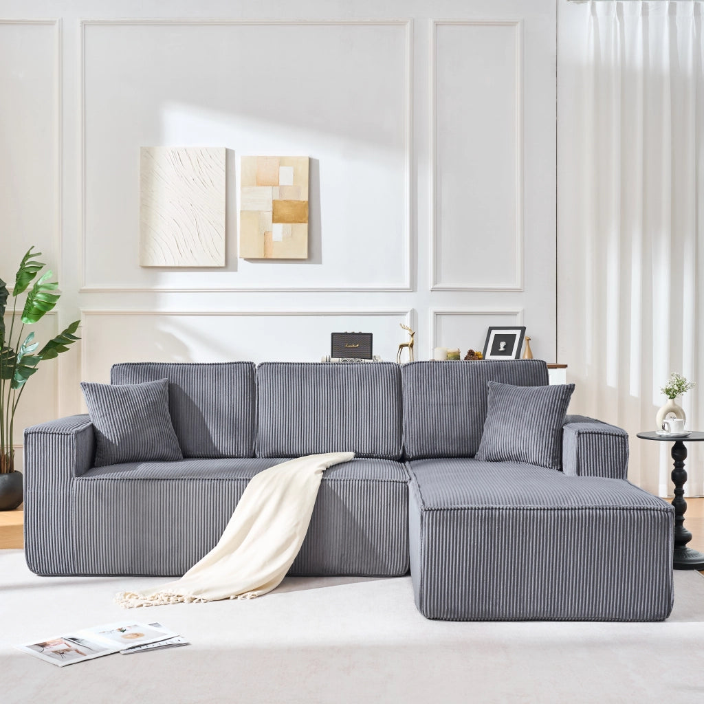 Divano angolare modulare 2 posti con chaise longue, due cuscini e braccioli larghi in velluto a coste grigio