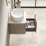 Mobile bagno sospeso 60 cm con lavabo ovale bianco in ceramica, piano in travertino sinterizzato e armadietto in compensato con cassetto, finitura rovere crema, preassemblato