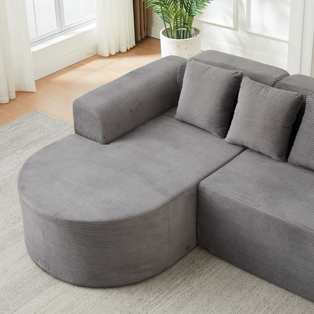 Divano modulare a L grigio in velluto a coste con forme curve
