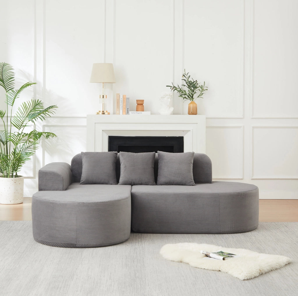 Divano modulare a L grigio in velluto a coste con forme curve
