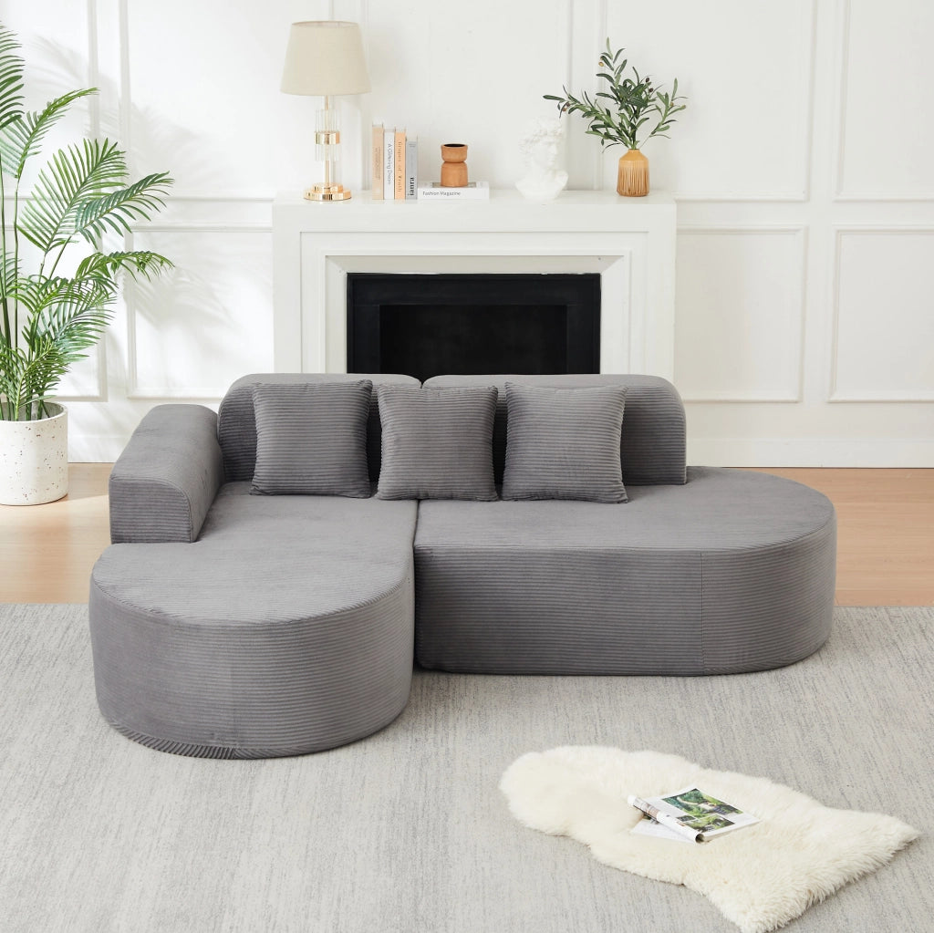 Divano modulare a L grigio in velluto a coste con forme curve