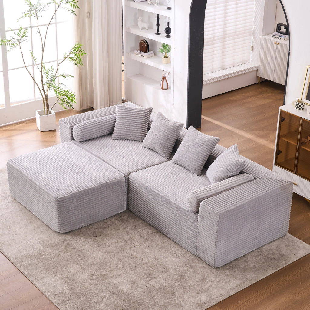 Divano componibile grigio a tre moduli con chaise longue