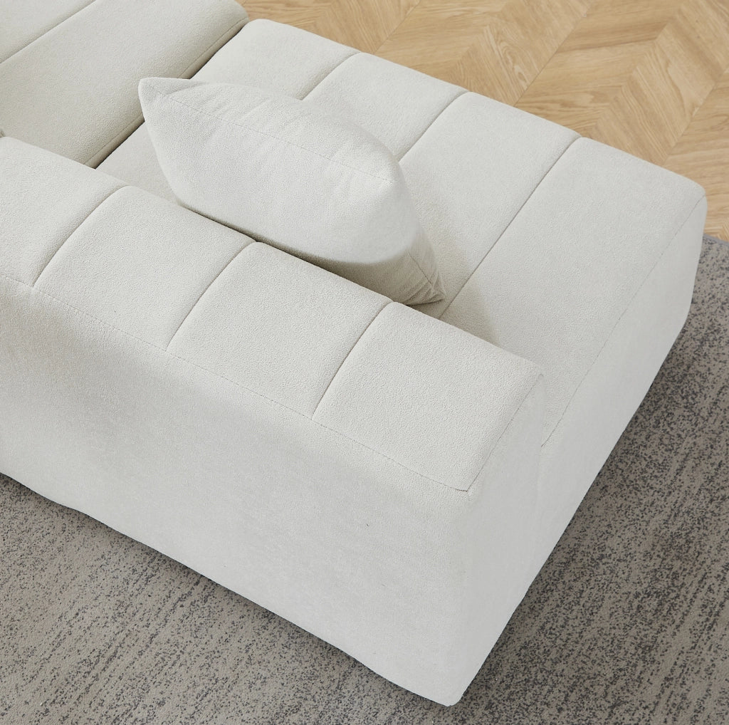 Divano modulare curvo in ciniglia beige con due cuscini