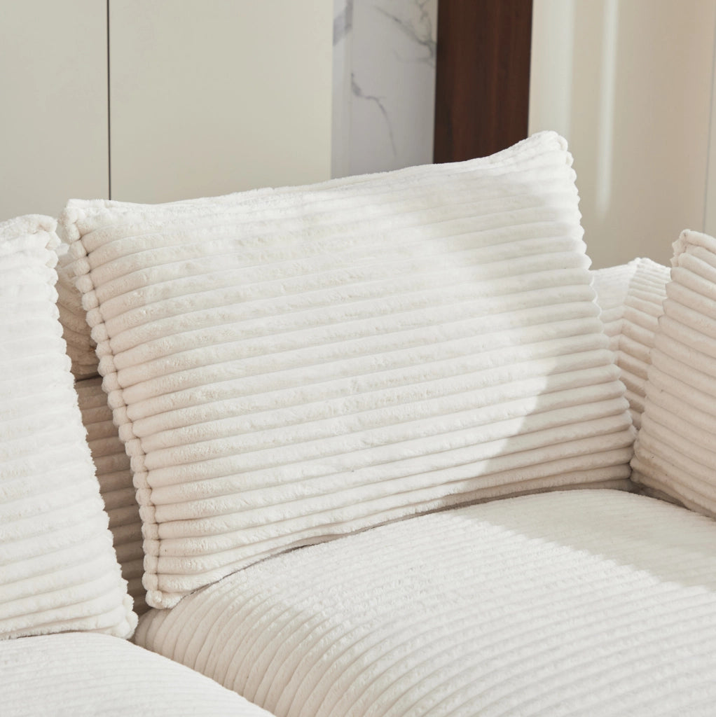 Divano modulare in velluto a coste beige con cuscini e tasche laterali