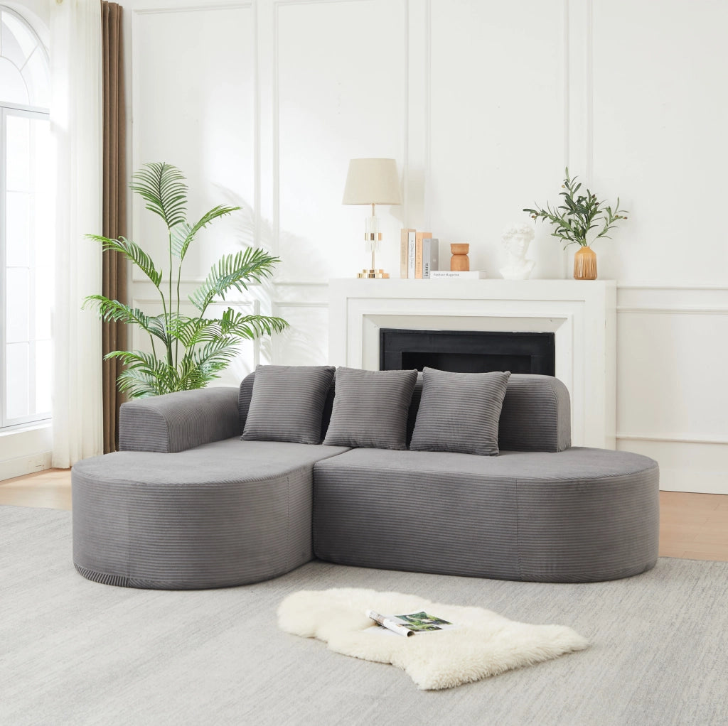 Divano modulare a L grigio in velluto a coste con forme curve