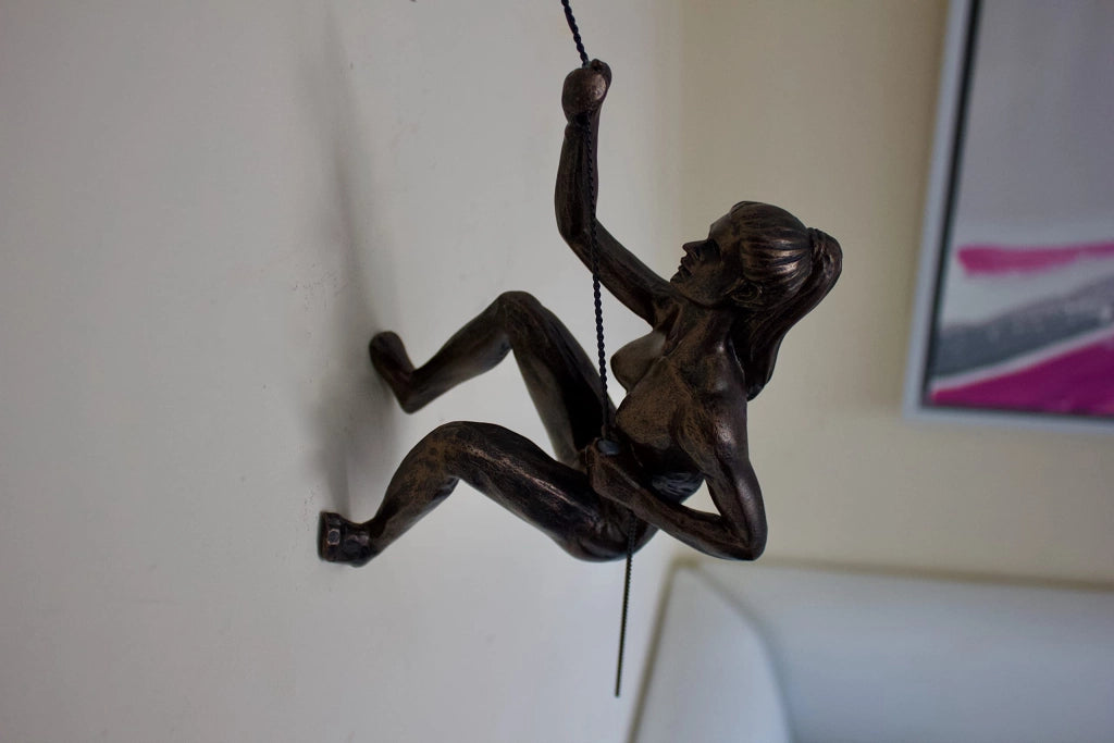 Figura in bronzo di una donna che arrampica, con base a forma di chiodo di roccia, altezza 73 cm