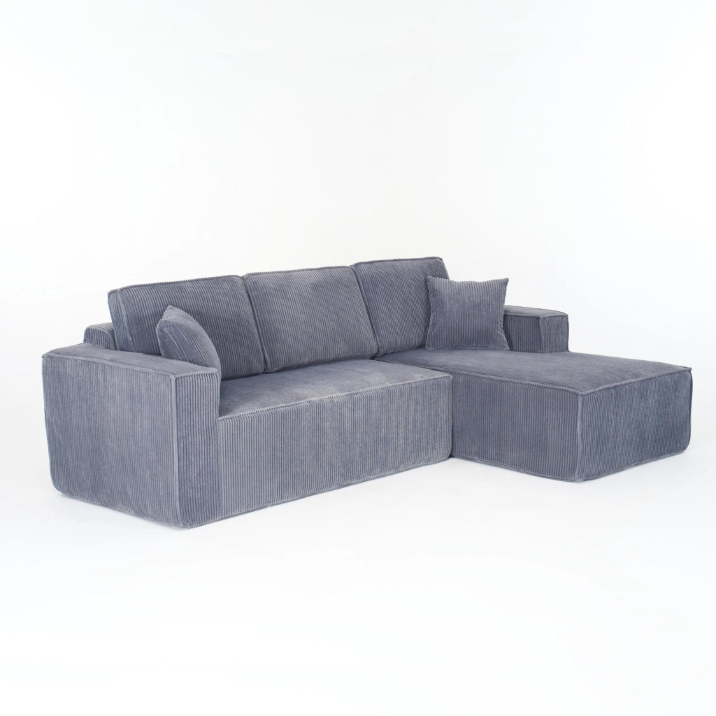 Divano angolare modulare 2 posti con chaise longue, due cuscini e braccioli larghi in velluto a coste grigio