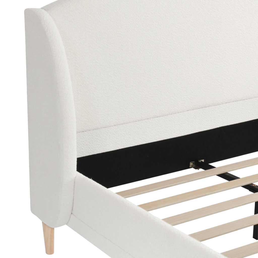 Letto imbottito con testiera ad ali e rivestimento bouclé